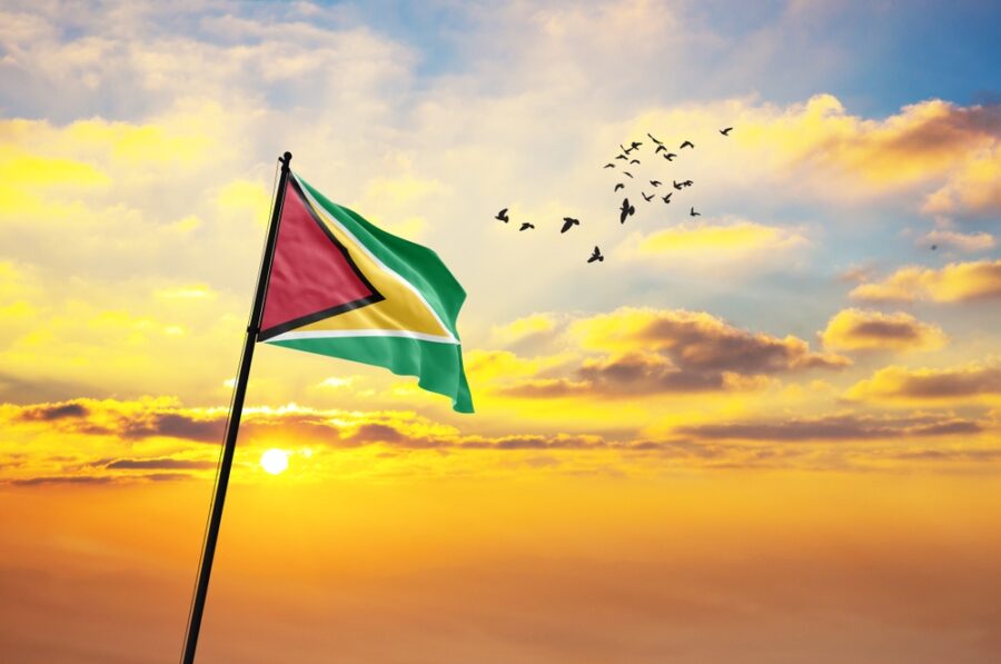 Waving,flag,of,guyana,against,the,background,of,a,sunset